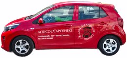 Rotes Auto mit Aufschrift „Agricola Apotheke Chemnitz“ – Fahrzeug für den Lieferservice der Apotheke mit Adresse und Telefonnummer.
